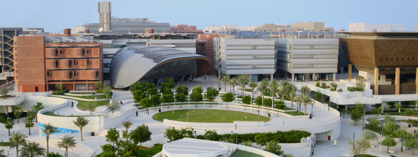 Aerial view of contemporary campus with dome-shaped building and landscaped circular plaza