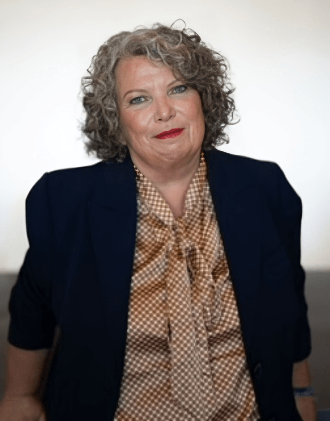 Confident woman with curly gray hair in blazer and blouse