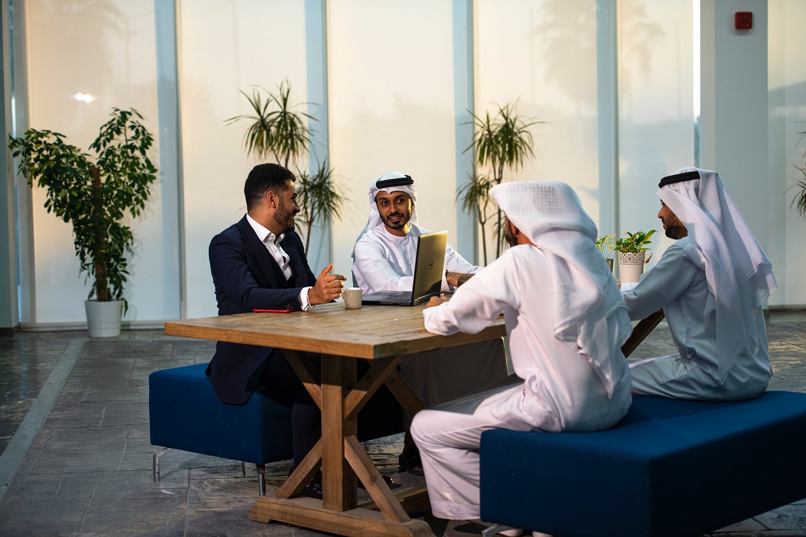 Diverse professional team in traditional Emirati and Western attire in a meeting