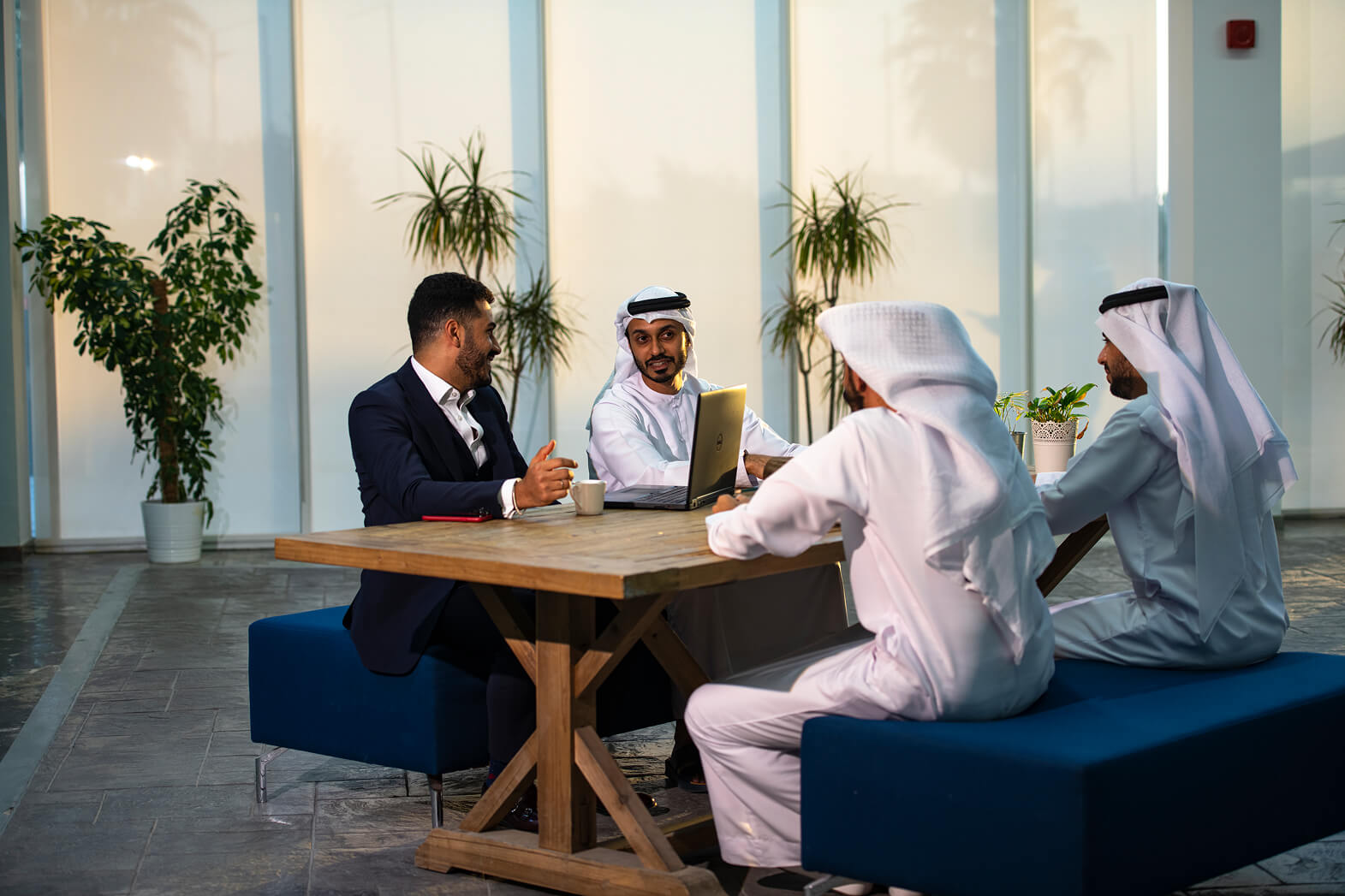 Diverse professional team in traditional Emirati and Western attire in a meeting