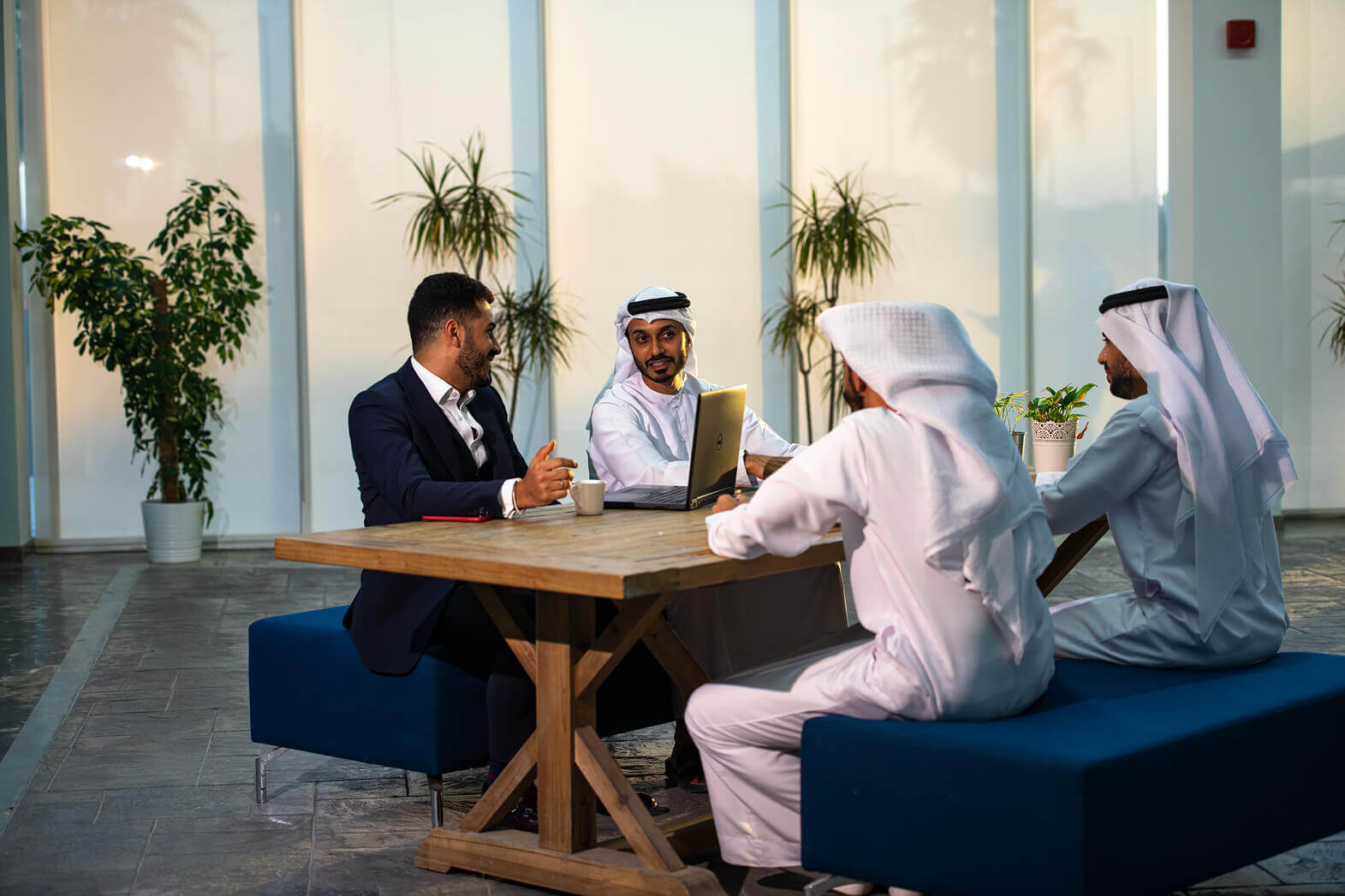 Diverse professional team in traditional Emirati and Western attire in a meeting