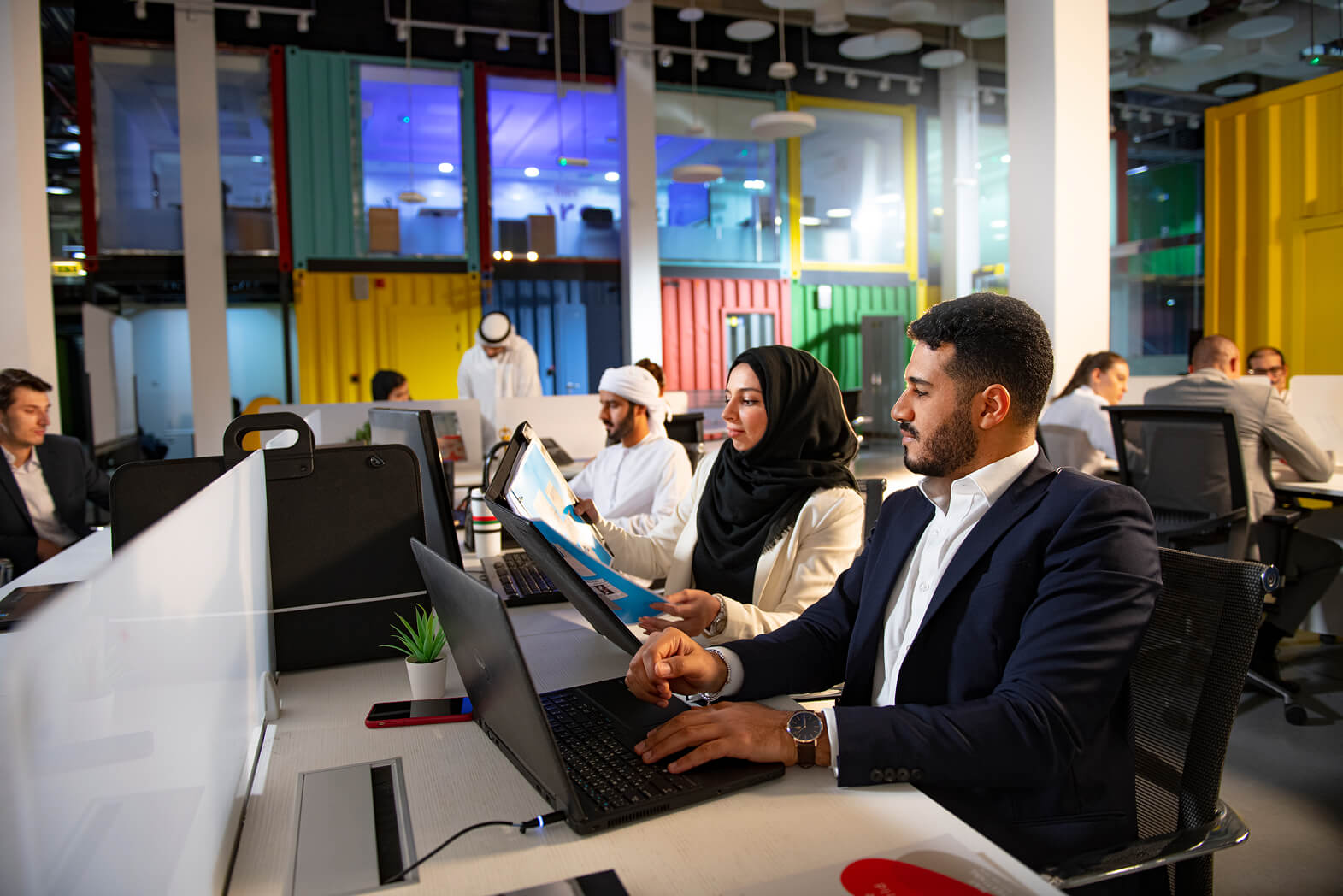 Diverse team collaborating in modern colorful office workspace